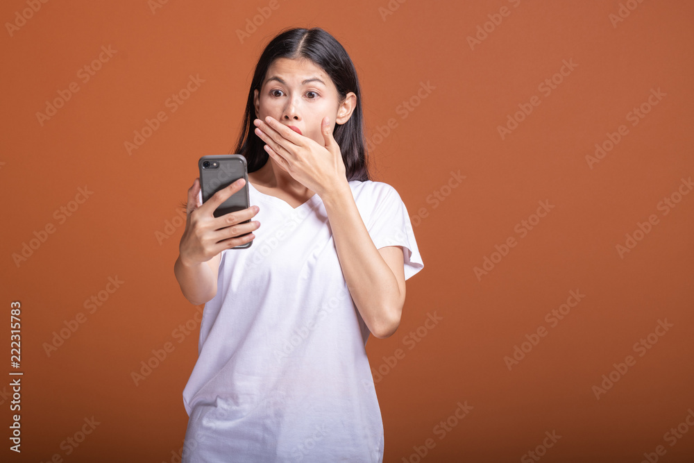 Woman using mobile phone isolated over orange background. Woman using mobile phone isolated over orange background.