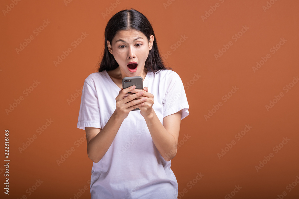 Woman using mobile phone isolated over orange background. Woman using mobile phone isolated over orange background.