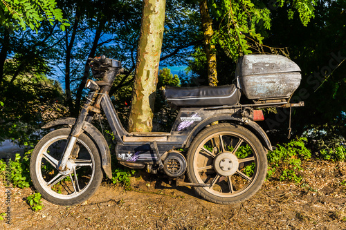 An old motorbike next to a tree - Ons Osland - Spain photo