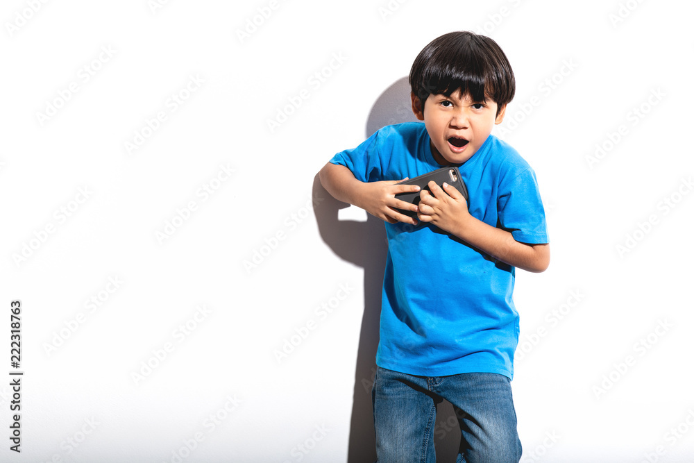 Young boy playing mobile game portrait in white background with hard light.