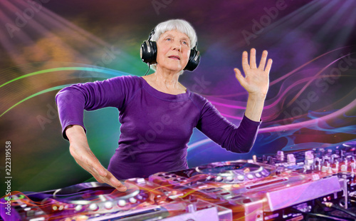 cheerful elderly woman plays music on a DJ console. A disco party in a nightclub for young and overweight people. Age of health, leisure, entertainment in retirement