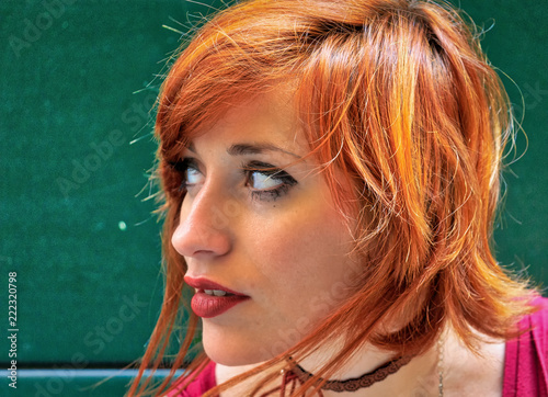 Lo sguardo rivolto a destra di una ragazza con i capelli rossi photo