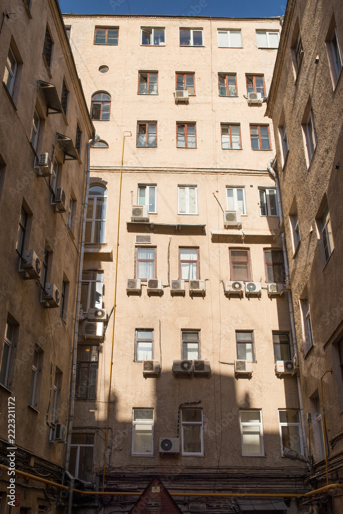 view on 3 biege walls facades in well yard on sunny spring day, Moscow, Russia