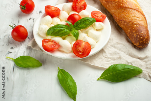 Mozzarella with basil leaves - fresh ingredients for Bruschetta, with cherry tomatoes and French baguette photo