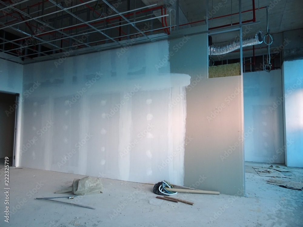 Foto de Drywall installation work in progress by construction workers