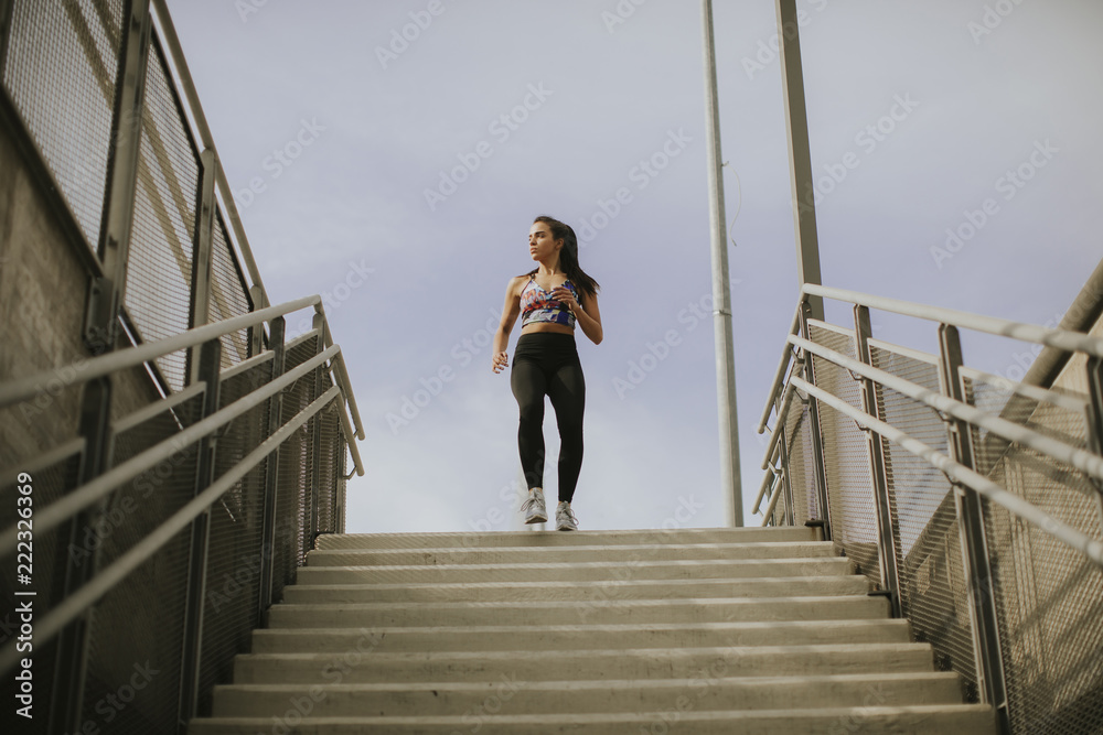 Young woman running alone down the stairs