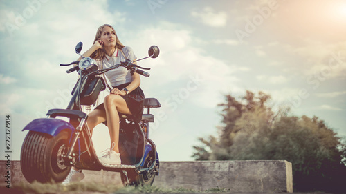 Young Woman Riding Electro Scooter On Country Road