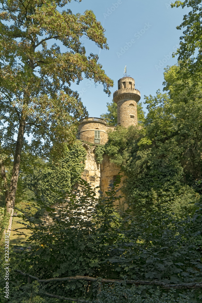 An old, historic defensive tower hidden between trees.