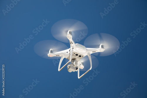 фотографія Drone Quadcopter From Below Against A Blue Sky
