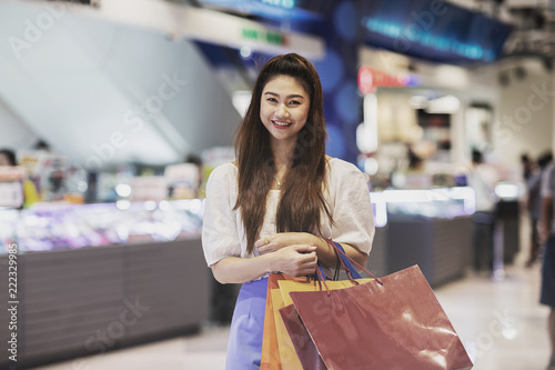 Happy Attractive Asian Woman smile and enjoy with shopping bags in shopping mall,Shopping Concept