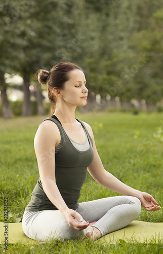 young slender girl meditating in lotus position. breathing exercises. practice of yoga.young woman doing breathing exercises.