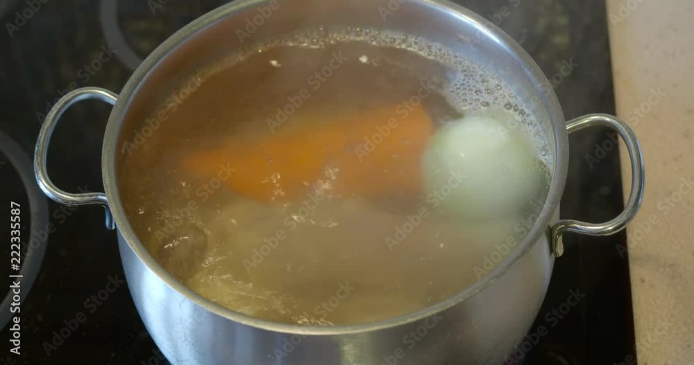 boiling beef broth in steel stewpot on ceramic cooker boiling beef broth in steel stewpot on ceramic cooker