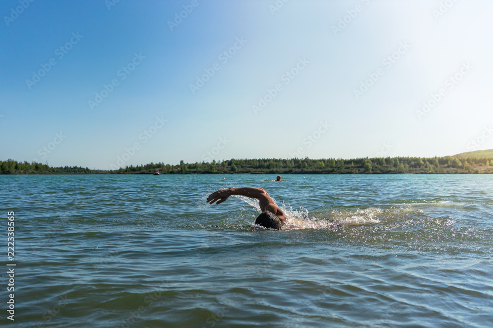 Man swimming in a lake, open water swim in summer