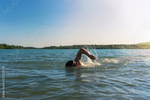 Man swimming in a lake, open water swim in summer
