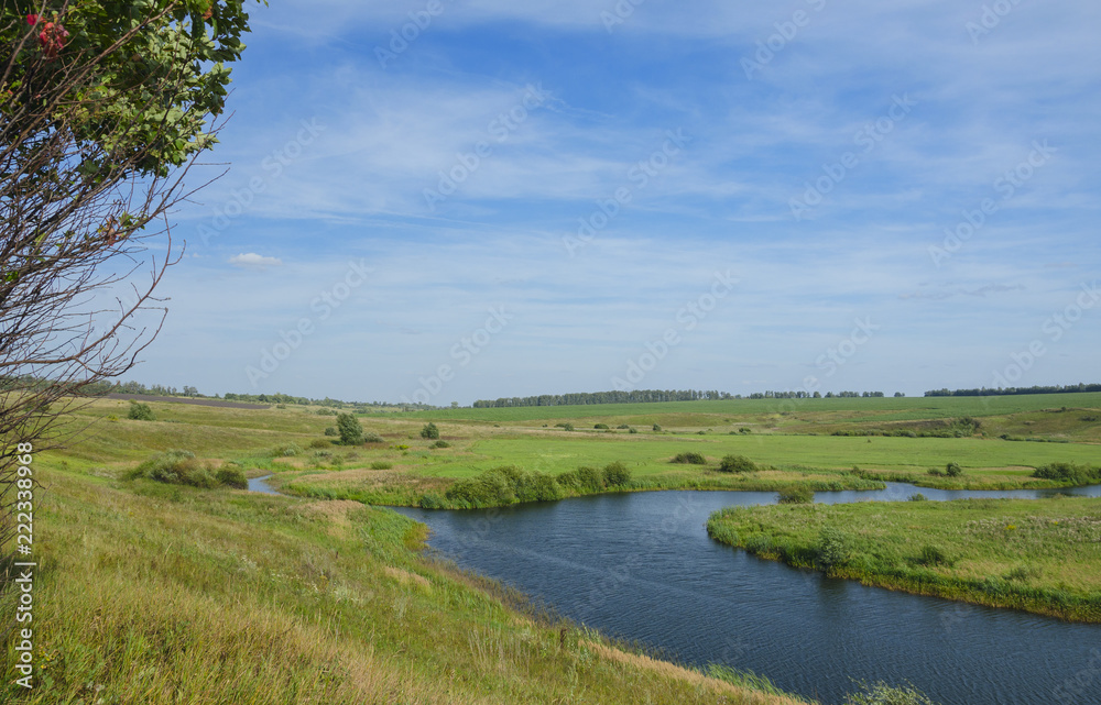 Sunny summer landscape with river,green meadows and fields.