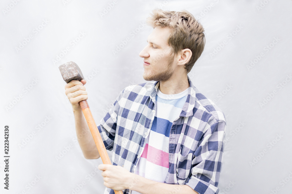 angry concept, young man in casual holding hammer isolated with copy space f angry concept, young man in casual holding hammer isolated with copy space f