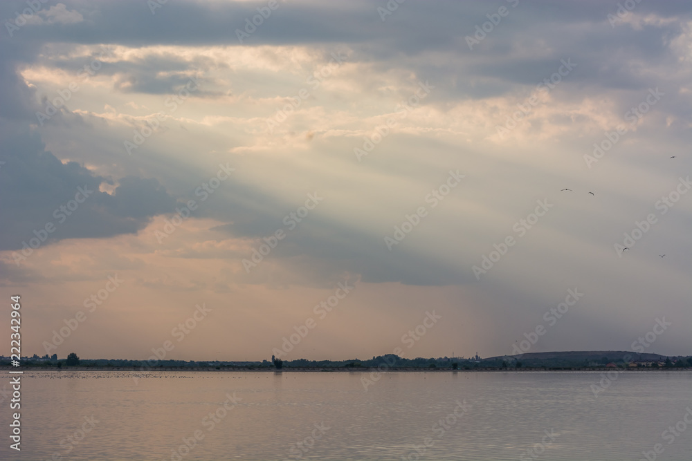 Sun Rays Illuminating Through Clouds to the Right Side of the Lake