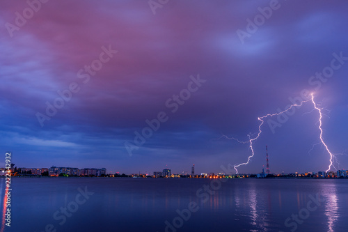 Lightning striking above the city at dusk