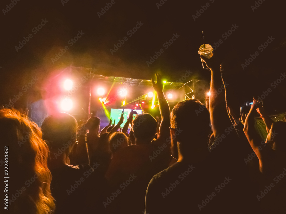 The party, concert concept. Crowd raising their hands and enjoying great rock festival. blur bokeh for background.