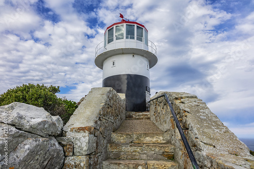 Old lighthouse (1857) sits on top of cliffs of Cape Point in Cape of Good Hope Nature Reserve on southern tip of Cape Peninsula in South Africa. The Atlantic and Indian oceans converge at Cape Point.