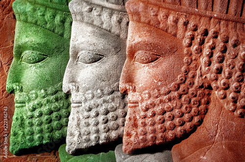 Persepolis. Iran. Ancient Persia. Bas-relief carved on the walls of old buildings. Colors of national flag of Iran.