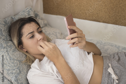 Nervous woman reading telephone message photo