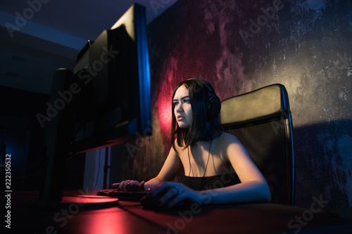 Fototapeta Portrait Shot of a Smiling Beautiful Professional Gamer Girl Playing in First-Person Shooter Online Video Game on Her Personal Computer
