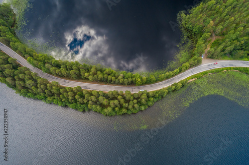 Road on a narrow piece of land between two lakes with forest