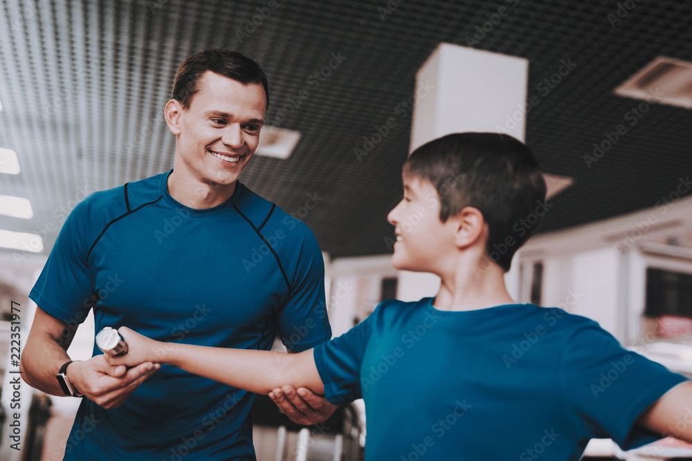 Young Father and Son Doing Exercises in Sport Club Young Father and Son Doing Exercises in Sport Club