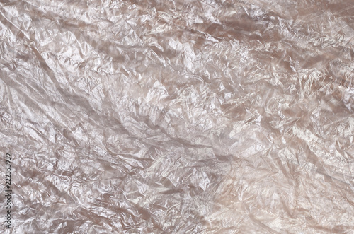 Texture of white crumpled cellophane surface transparent on sunlight. Concept of materials for packaging, product protection against damage photo