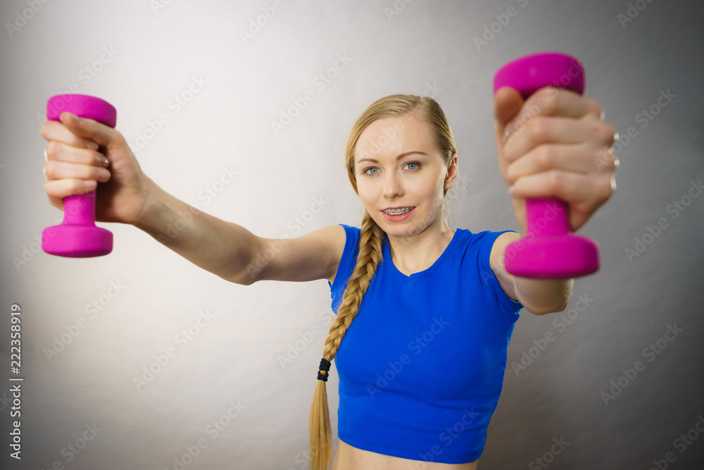 Teenage woman working out at home with dumbbell Teenage woman working out at home with dumbbell