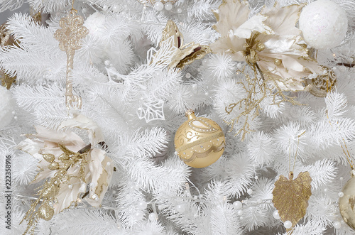 Decorating Christmas tree close up. Decoration bulb, white fir tree, golden x-mas toys and lights. Use for Christmas and New years celebration background photo