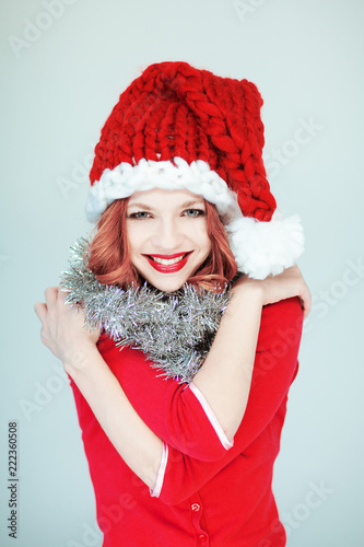 Beautiful happy young woman in a santa claus costume with perfect make up and red lipstick
