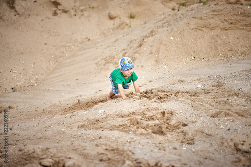 a child climbs a sand hill