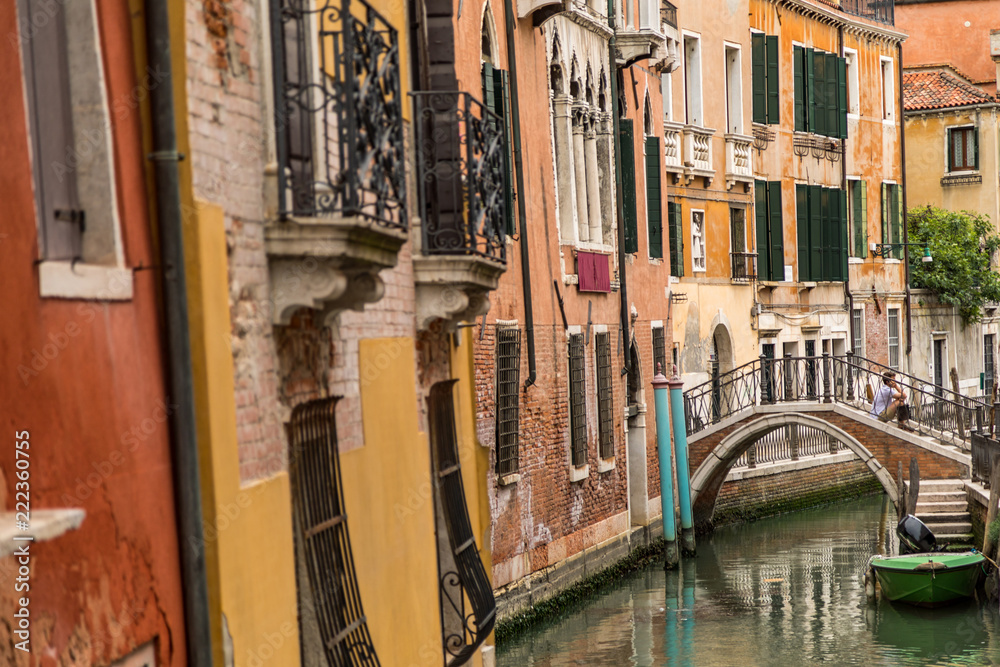Venice, Italy, the lagoon town, viewing old alleys along small canals with historic buildings at a sunny day in summer.