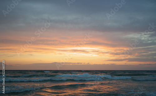 Beach at sunset with big clouds and colors in Salento - Italy