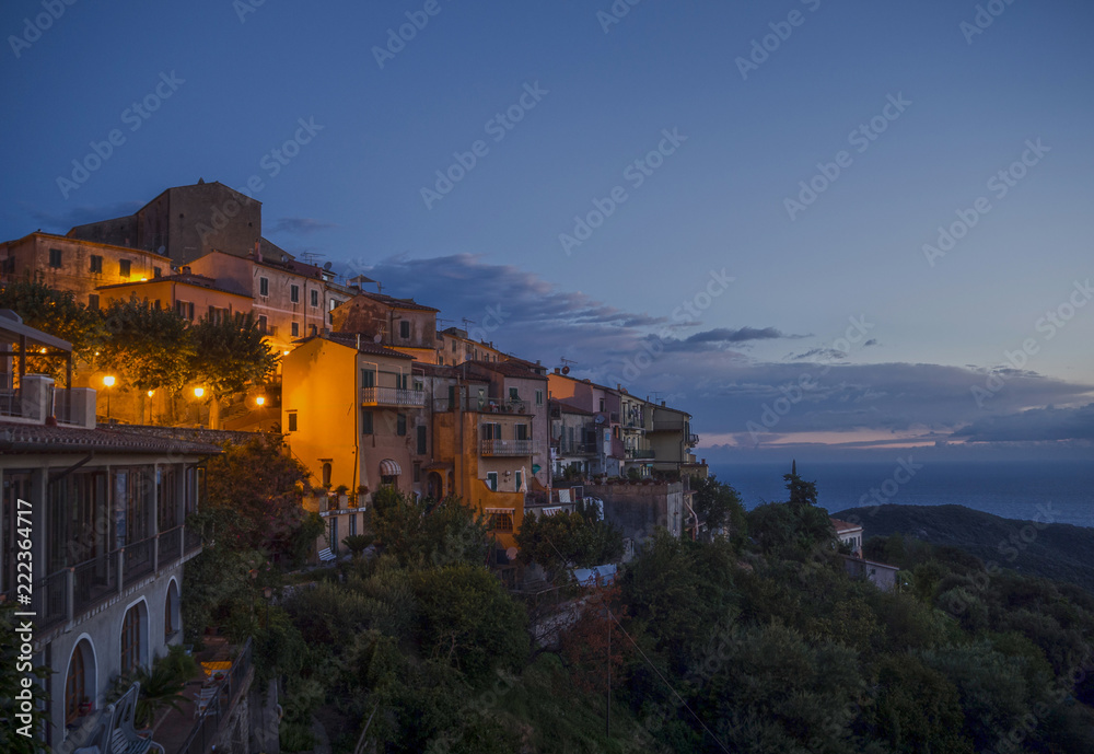 sunset view of an italian town on a hill, near the sea