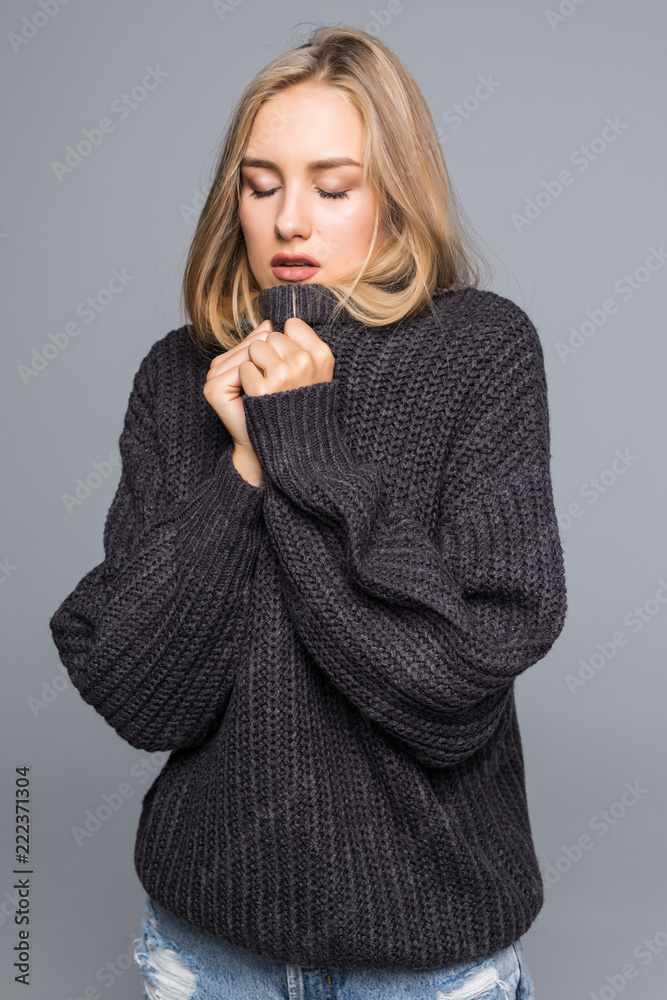 Portrait of a young happy woman in warm winter outfit on gray background Portrait of a young happy woman in warm winter outfit on gray background