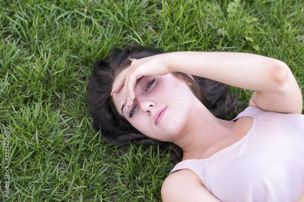 Brunette woman resting outside on grass Brunette woman resting outside on grass