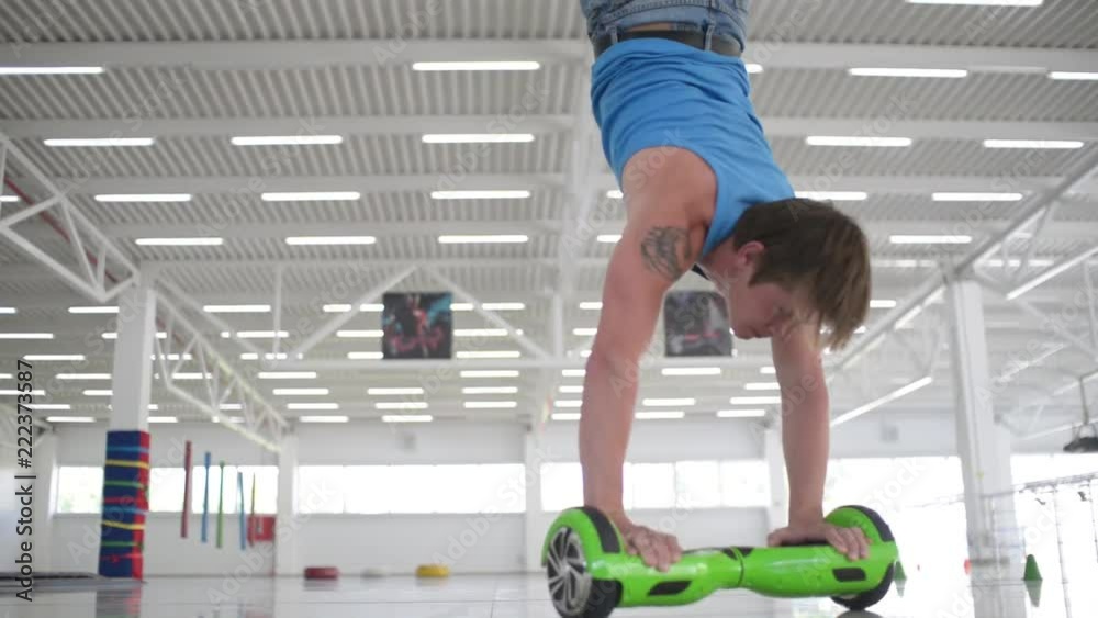 Man acrobat balancing motorized scooter - shows tricks