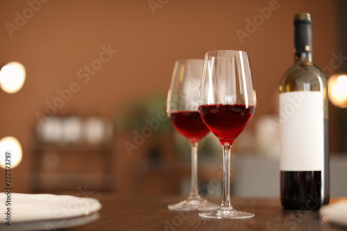 Glasses and bottle with tasty wine on table in restaurant