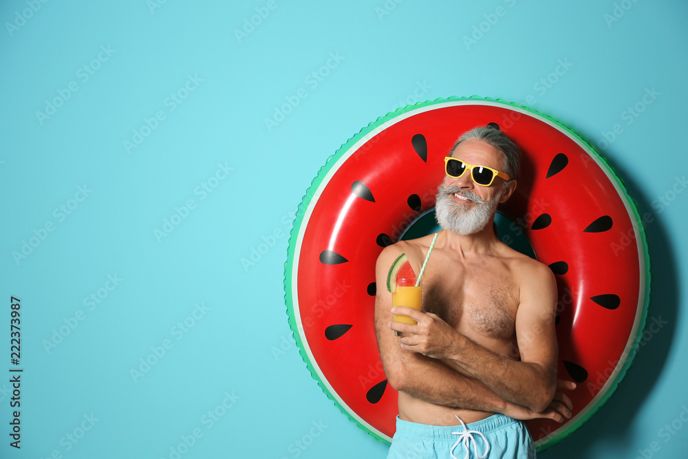 Wunschmotiv: Shirtless man with inflatable ring and glass of cocktail on color background #222373987