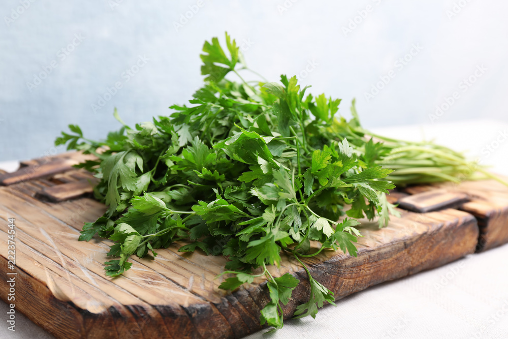 Wooden board with fresh green parsley on table Wooden board with fresh green parsley on table