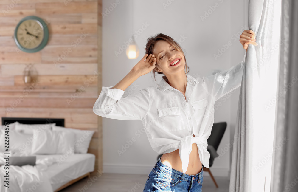 Young happy woman near window at home. Lazy morning Young happy woman near window at home. Lazy morning