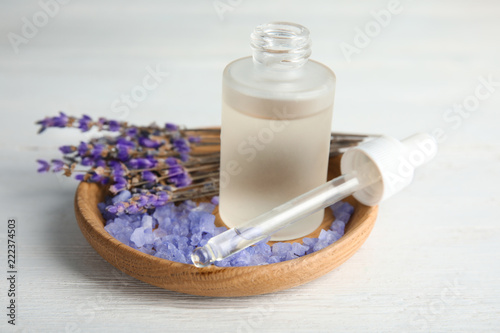 Fototapeta Naklejka Na Ścianę i Meble -  Bottle with aromatic lavender oil on white wooden table