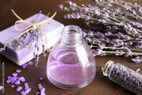 Fototapeta Naklejka Na Ścianę i Meble -  Bottle with aromatic lavender oil on wooden table