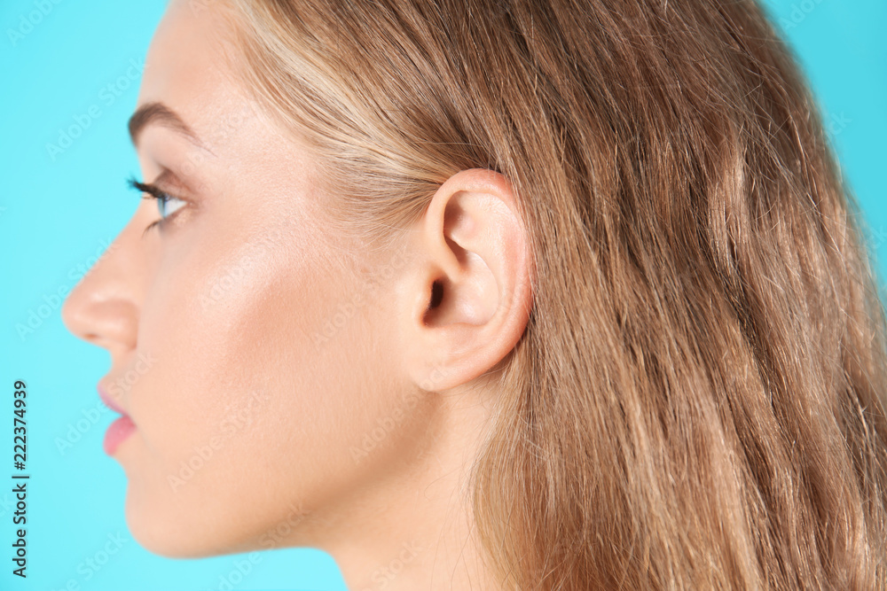 Young woman on color background, closeup. Hearing problem Young woman on color background, closeup. Hearing problem