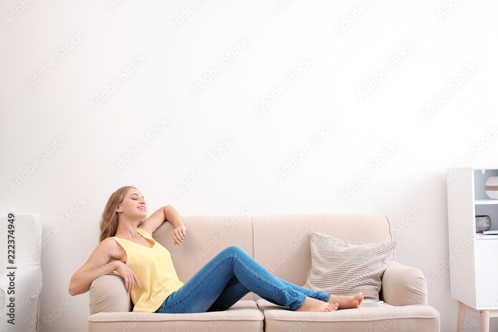 Young woman relaxing under air conditioner at home Young woman relaxing under air conditioner at home