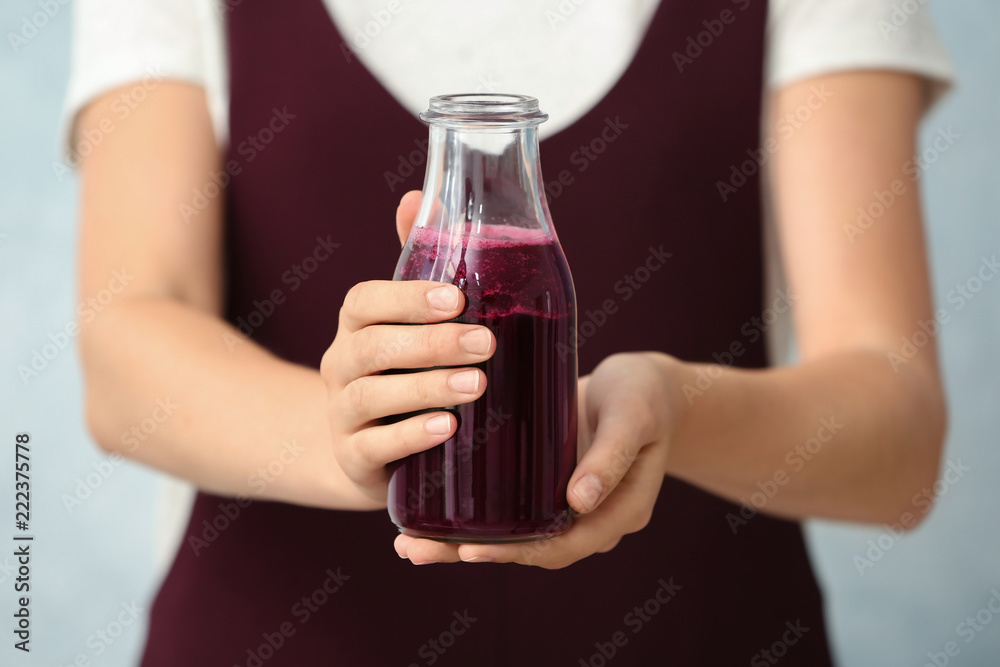 Woman with bottle of beet smoothie on light background, closeup Woman with bottle of beet smoothie on light background, closeup