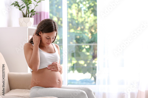 Pregnant woman sitting on sofa at home Free Download Pregnant woman sitting on sofa at home - GFXLoad